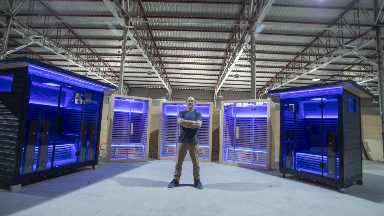 a man standing behind full spectrum infrared saunas